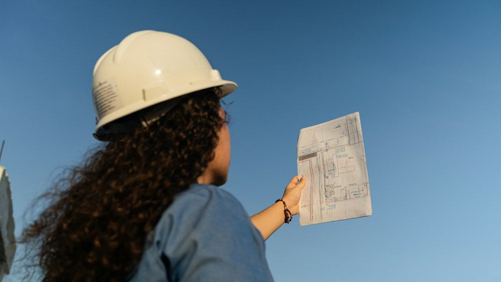 Ingénieure en casque de chantier consultant un plan